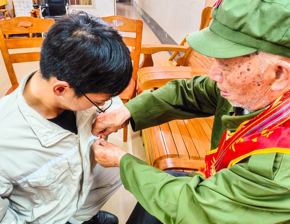 2、韋仕隆給新入黨的青年黨員佩戴黨章--李陽攝.jpg